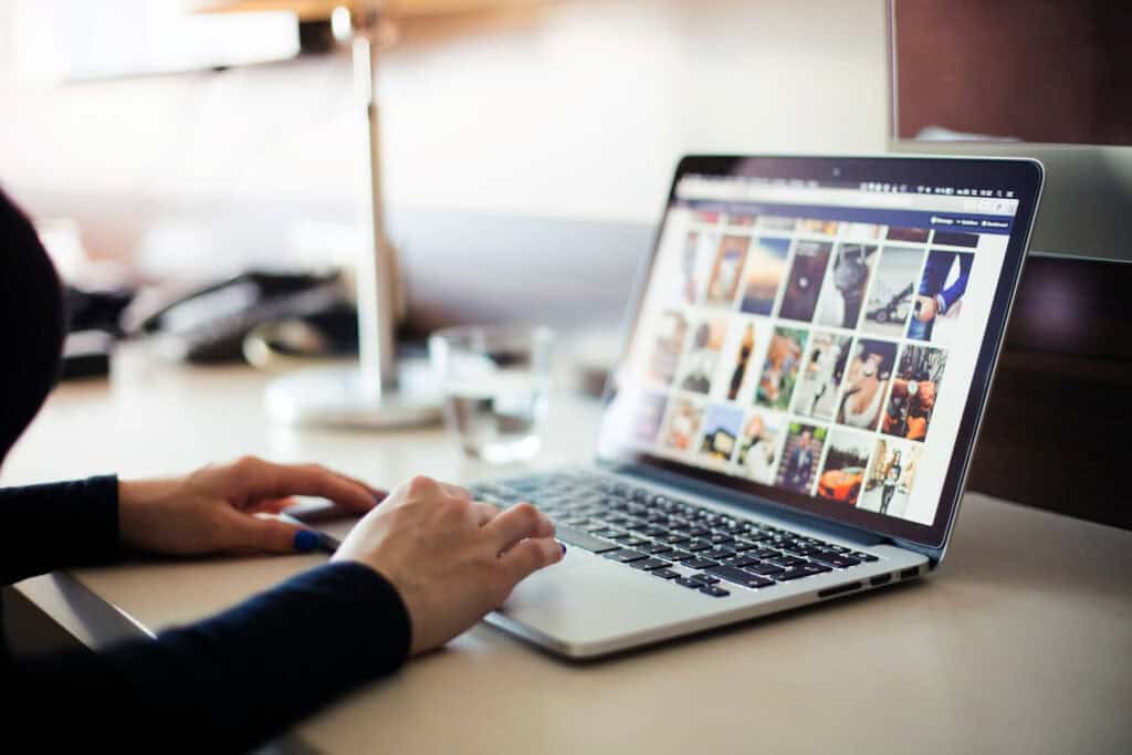Person using a laptop to browse a website, emphasizing importance of online presence for business su.